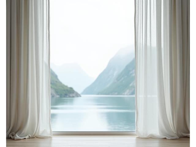 Lyse, lette gardiner ved et stort vindu med havutsikt