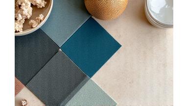 Ordnet samling av materialprøver og møbelkataloger på et designkontor